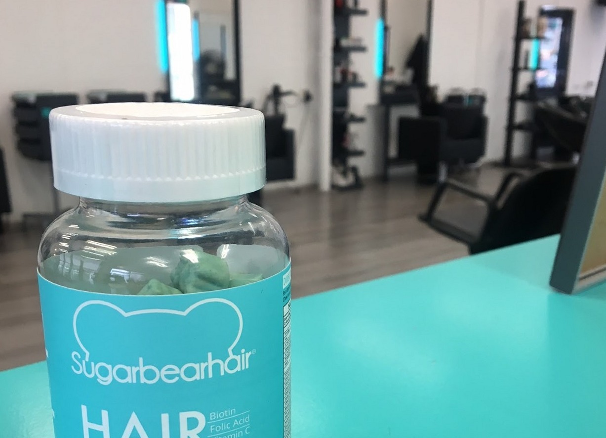 Een turquoise SugarBearHair-potje op de balie in de salon